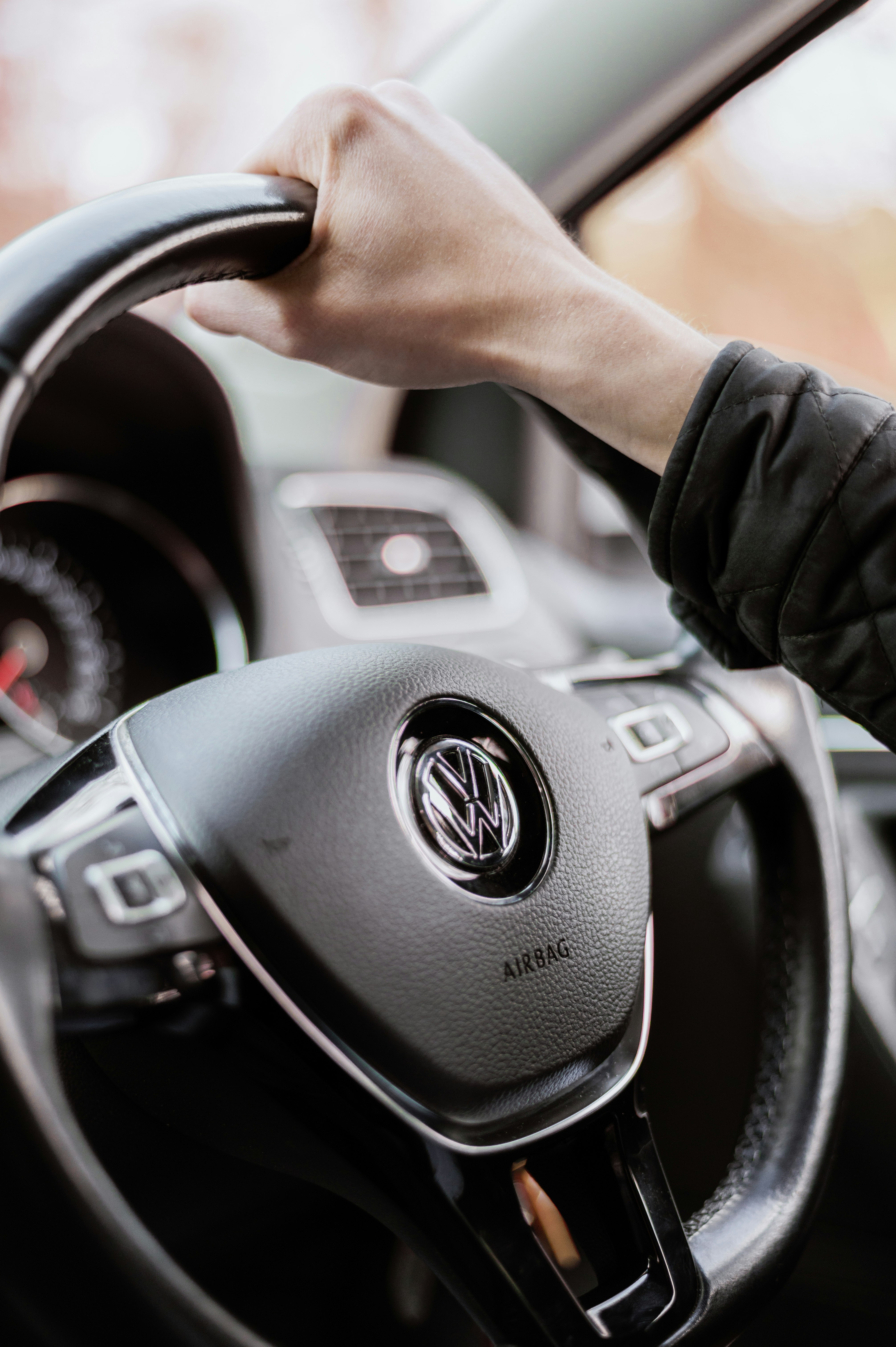 person holding black mercedes benz steering wheel